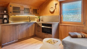 Eine Küche mit Holzvertäfelung, einem Spülbecken, einem Herd und Schränken.