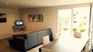 Un salon moderne avec un canapé, une table à manger et un téléviseur.