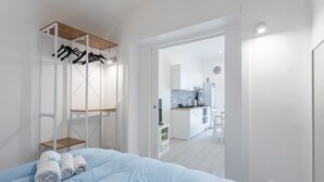 Une chambre à coucher avec un lit, une étagère en bois et une armoire blanche.