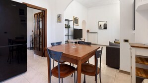Une cuisine moderne avec une table à manger, des chaises et un réfrigérateur.