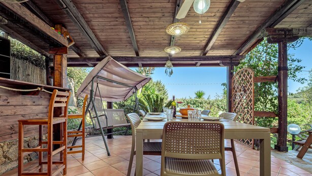 Une terrasse extérieure avec une table en bois, des chaises et une échelle.