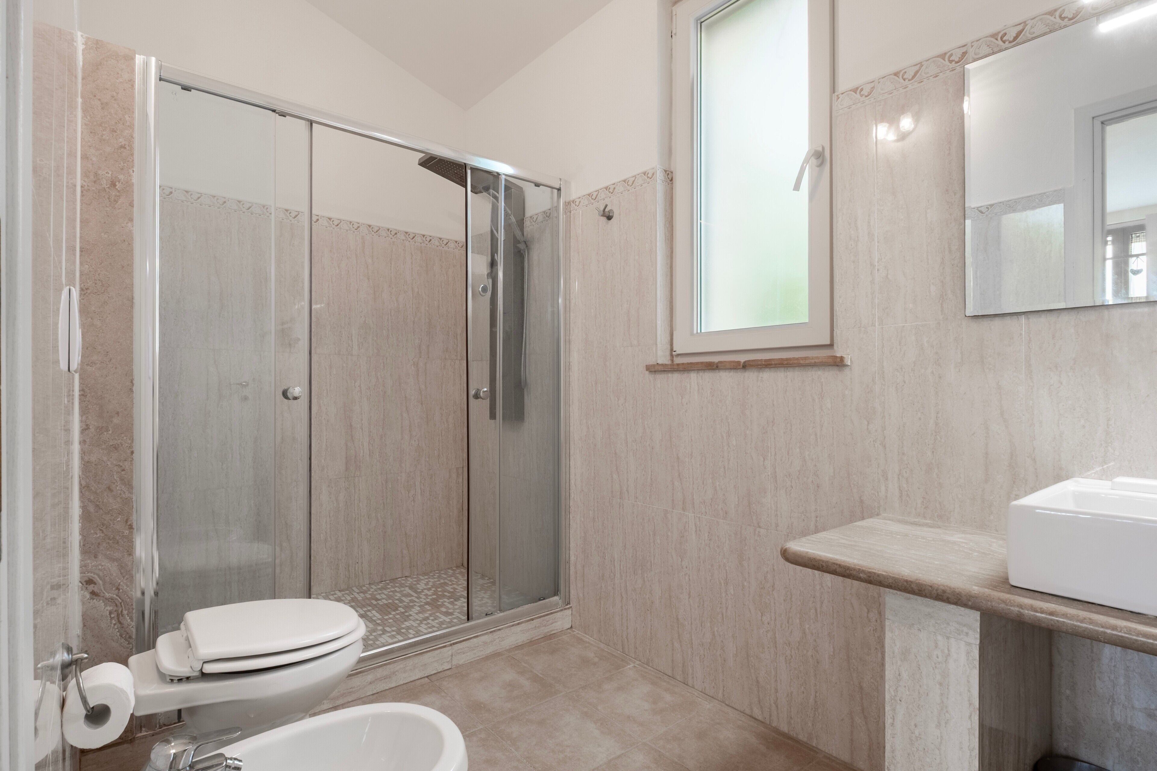 Ein Badezimmer mit Duschkabine, Toilette und Waschbecken.