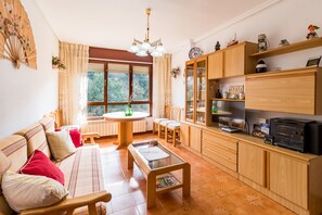 Un salon confortable avec un canapé, une table basse et un coin repas avec des chaises. Il y a également une cuisine avec des meubles en bois et une cuisinière.