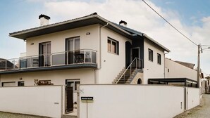 A two-story building with a balcony, a staircase, and a sign indicating 'Rua do Silva'. - Room 'Duplo Com Wc Privada' with Shared Garden and Wi-Fi (Apúlia)