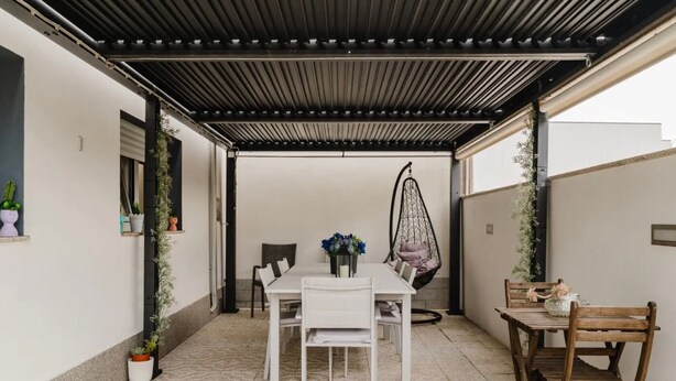 An outdoor patio with a table and chairs, a hanging chair, and potted plants. - Room 'Duplo Com Wc Privada' with Shared Garden and Wi-Fi (Apúlia)