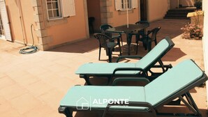 Un espace patio aménagé avec du mobilier d’extérieur, comprenant deux fauteuils et une table.
