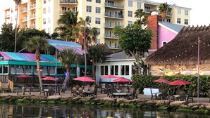 A waterfront restaurant with outdoor seating and a view of a building in the background. - Cozy Cottage, 2 Queens, 1 Twin, Patio, Shared Pool (Melbourne)