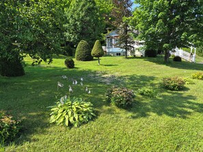 Un jardin bien entretenu, avec des pelouses impeccables, une variété d’arbustes et des plantes taillées avec soin.