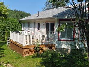 A single-story house with a porch, a chimney, and a fenced yard.