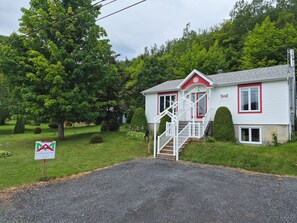 A two-story house with a red and white exterior, a front porch, and a staircase leading to the entrance.