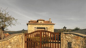 A stone building with a tiled roof, a wooden gate, and a stone wall. - Casa da Pedra by ALPONTE (Venade)
