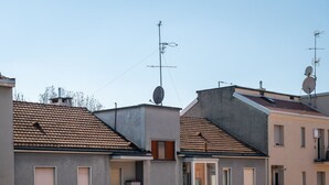 Un edificio residencial con varios balcones y antenas parabólicas.