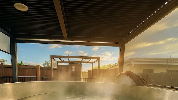 A hot tub with a wooden deck and a view of the sky. - Hot Spring Vacation House (Rotorua)