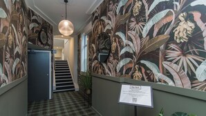 Un pasillo con piso a cuadros, una escalera y un letrero que indica una sala de reuniones.
