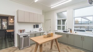 Una cocina moderna con una mesa de madera, electrodomésticos de acero inoxidable y un ventanal con vistas al exterior.