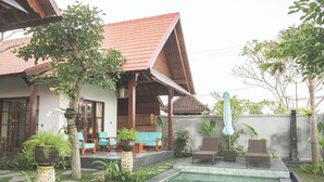 A traditional house with a tiled roof, a swimming pool, and outdoor seating. - Villa Puri Kembar – A Serene Escape with a Private Pool & Stunning Views (Bali)