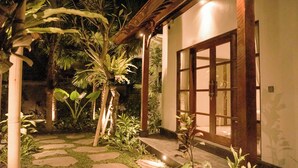 A garden pathway leading to a building with a wooden door and a small porch. - Villa Puri Kembar – A Serene Escape with a Private Pool & Stunning Views (Bali)