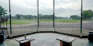 A view from inside a building with large windows overlooking a golf course. There are tables with papers on them, and a sign indicating a golf event. - Villa The Club SHIRAKAWA (Ten-ei)