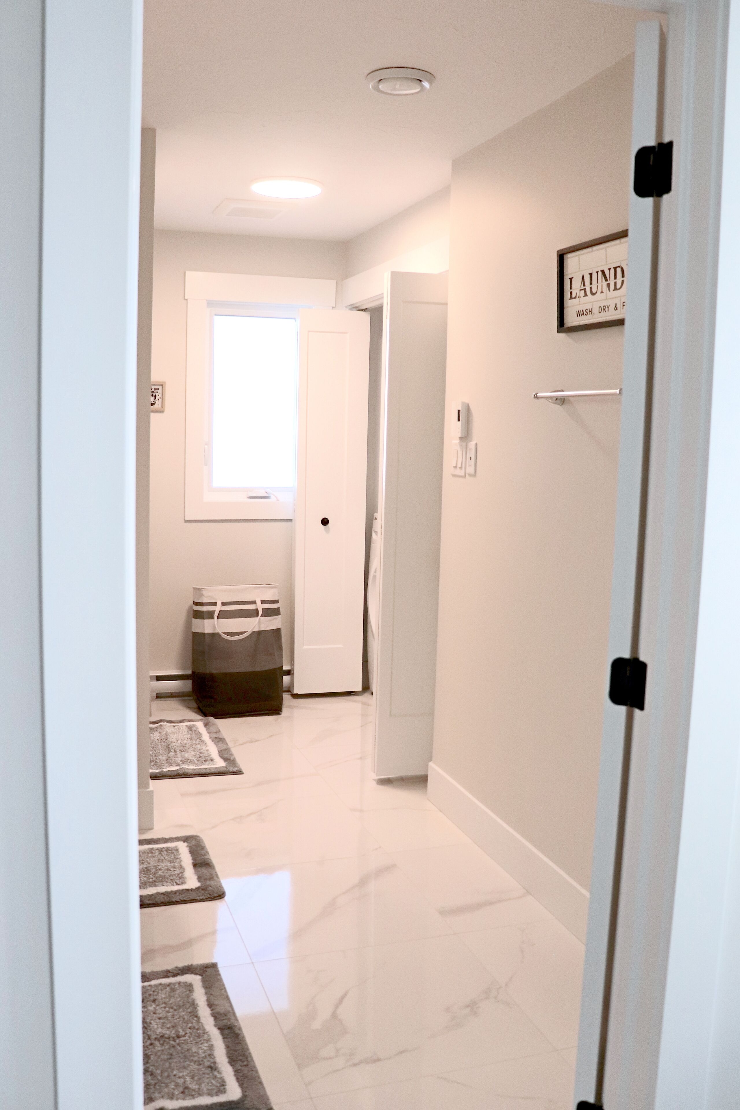 A hallway with a door labeled "LAUNDRY" and a bag on the floor.