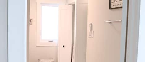 A hallway with a door labeled "LAUNDRY" and a bag on the floor.