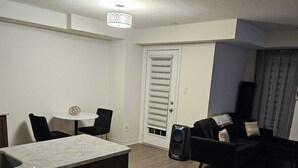 A modern living room with a kitchen area, a dining table, and a built-in island. - Cozy clean, family sized house. (Cambridge)
