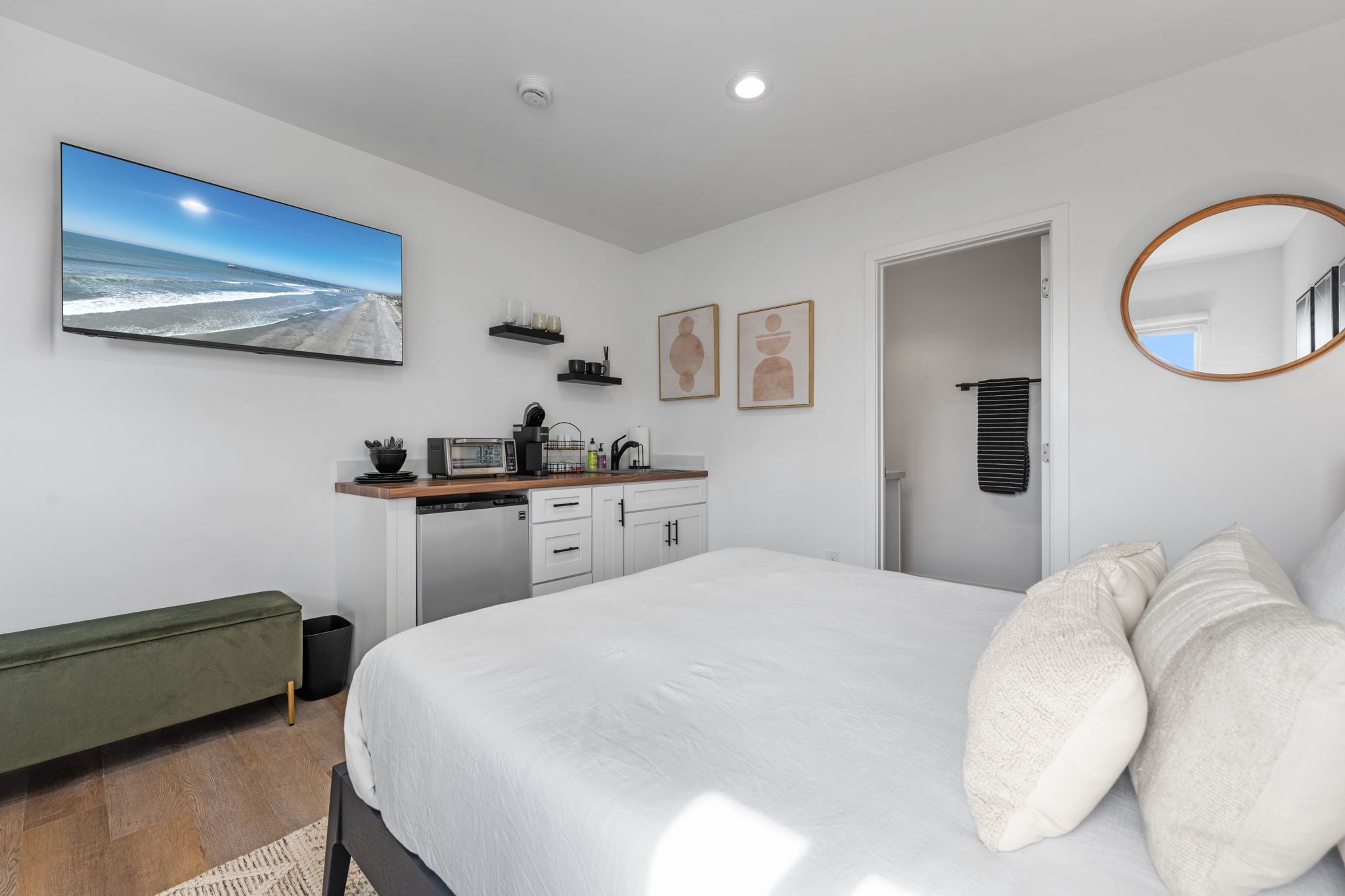 Une chambre moderne avec un grand lit, un bureau intégré et une vue sur la plage.