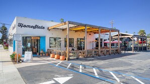A building with a sign reading "HomeState" and a covered outdoor seating area. - South Oceanside Bungalow 2 - Deluxe Queen Studio + Patio (Oceanside)