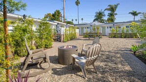 Un espace patio avec des sièges d’extérieur, un foyer et un petit jardin.