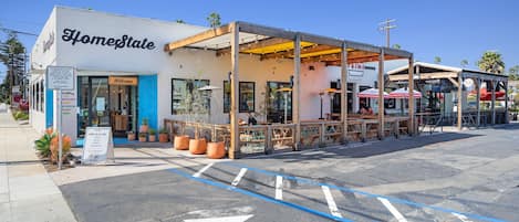 A building named 'HomeState' with a covered outdoor seating area and a 'Welcome' sign.