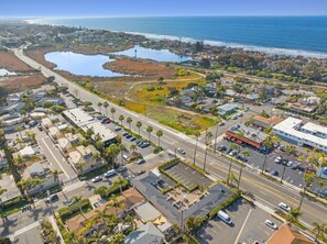 An aerial view of a coastal town with a marina, roads, and residential areas.