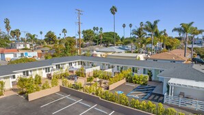 Ein Motel mit mehreren Zimmern, einem Parkplatz und einem kleinen Poolbereich.