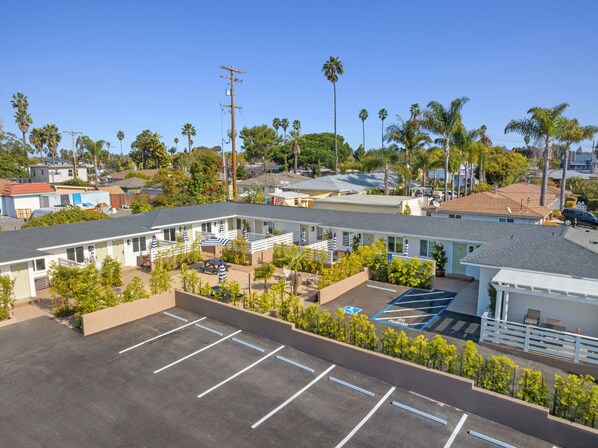 A motel with multiple rooms, a parking lot, and a small pool area.