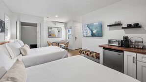 Une chambre d’hôtel avec deux lits, une kitchenette, un coin repas et une salle de bain.
