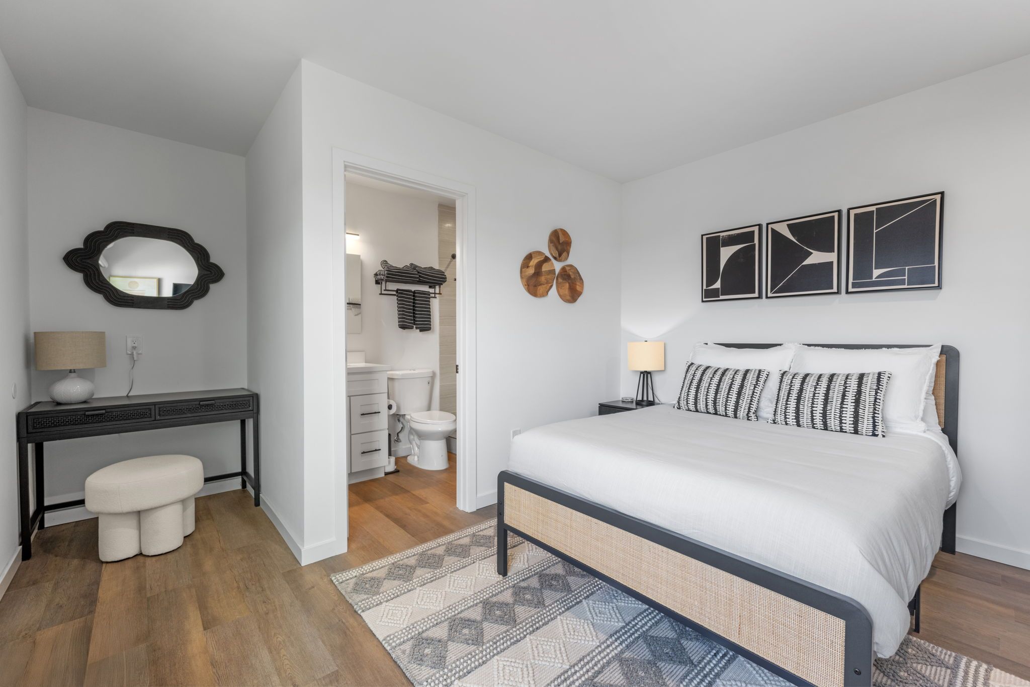 Une chambre à coucher avec un lit, des tables de chevet, un miroir et une commode.