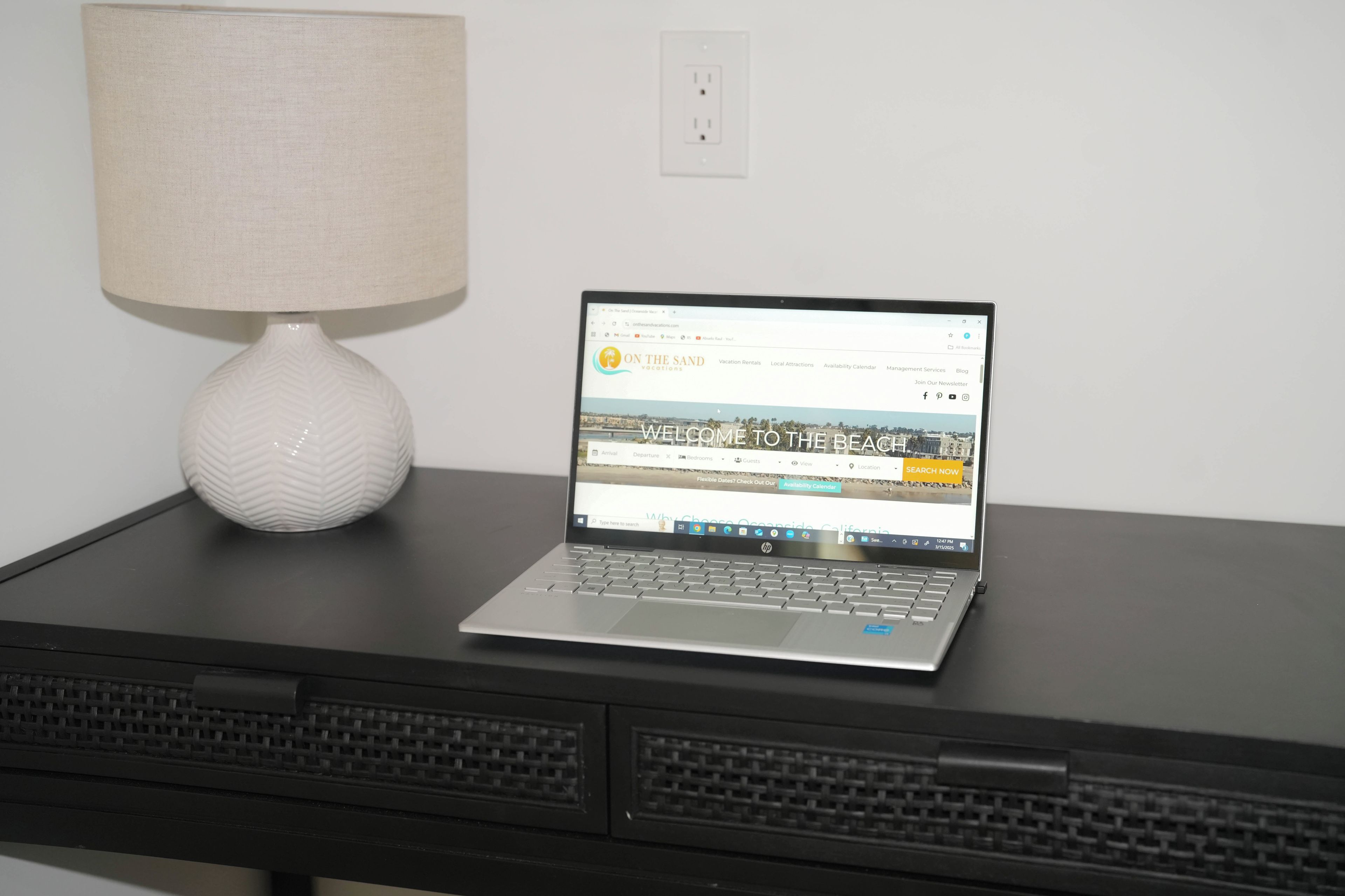 A laptop on a desk with a lamp beside it.