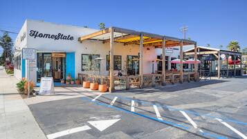 A building named 'HomeState' with a covered outdoor seating area and a 'Welcome' sign.