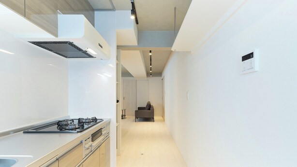 Una cocina moderna con estufa a gas, armarios de madera y piso de color claro.