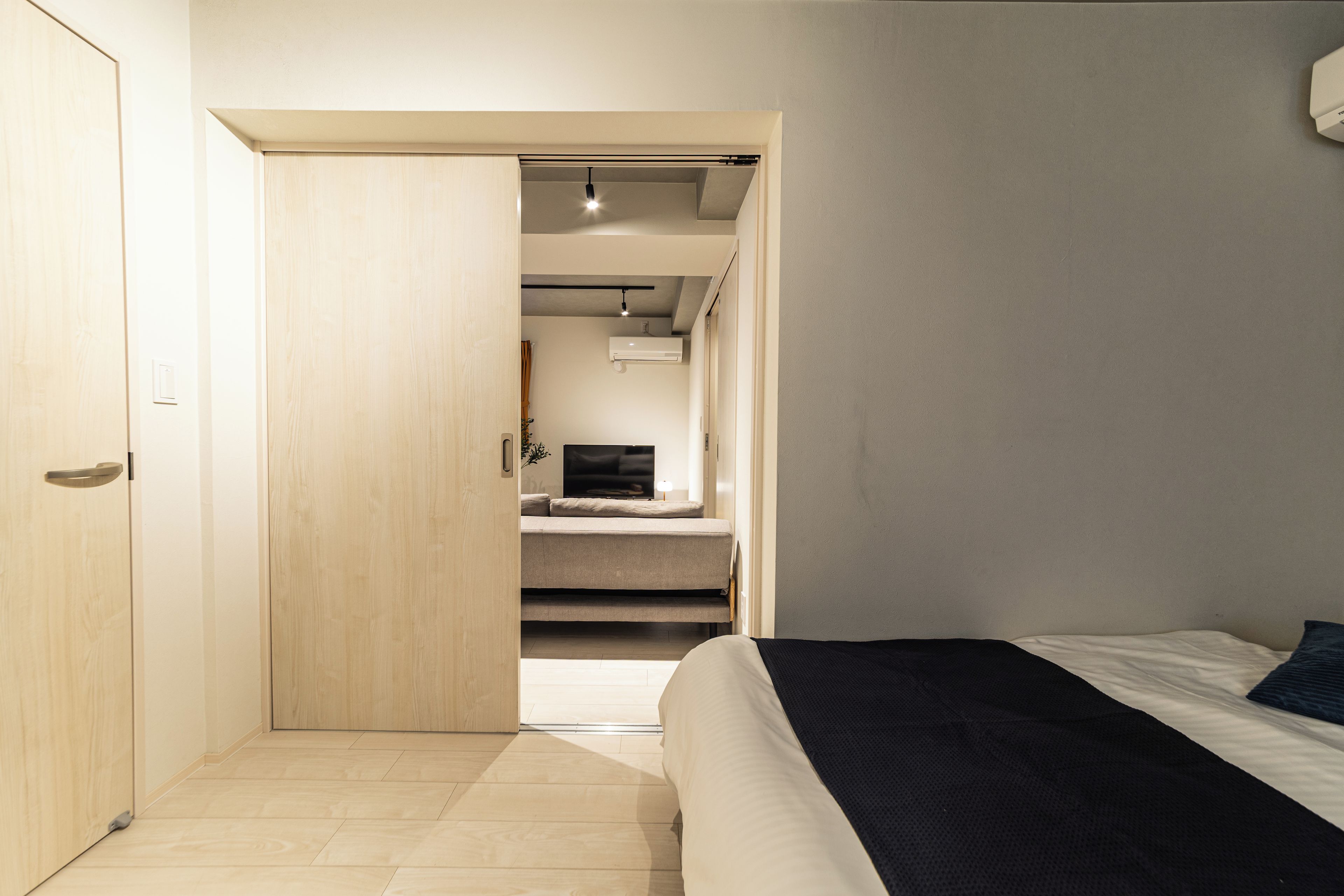 A bedroom with a bed, a desk with a chair, and a wardrobe.