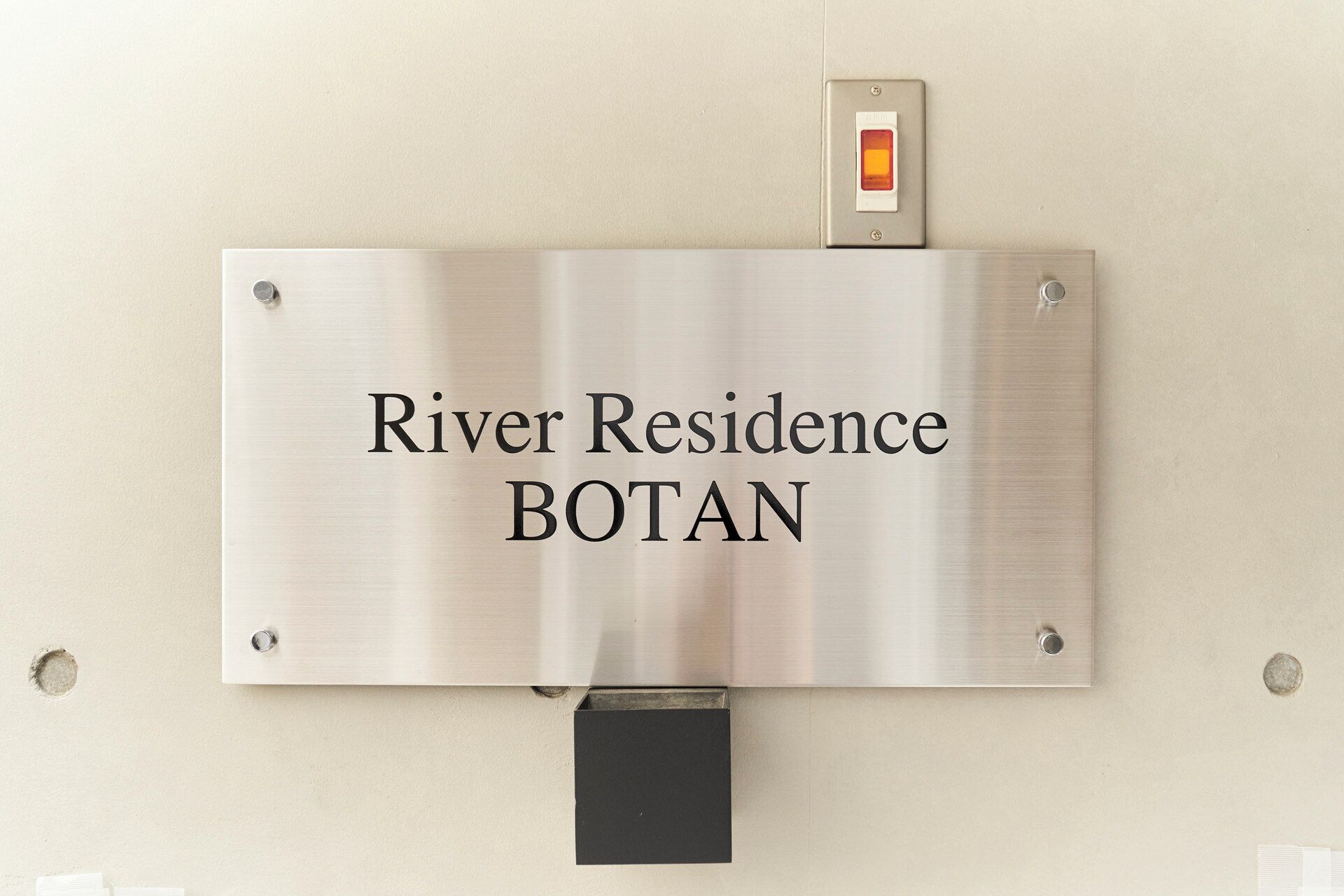 Een bord met de tekst 'River Residence BOTAN' dat een locatie of kamer aangeeft.
