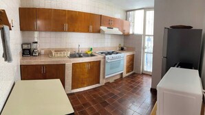 A kitchen with wooden cabinets, a stove, a sink, and a refrigerator. - Rest house for 16 people Xochitepec Morelos (Xochitepec)