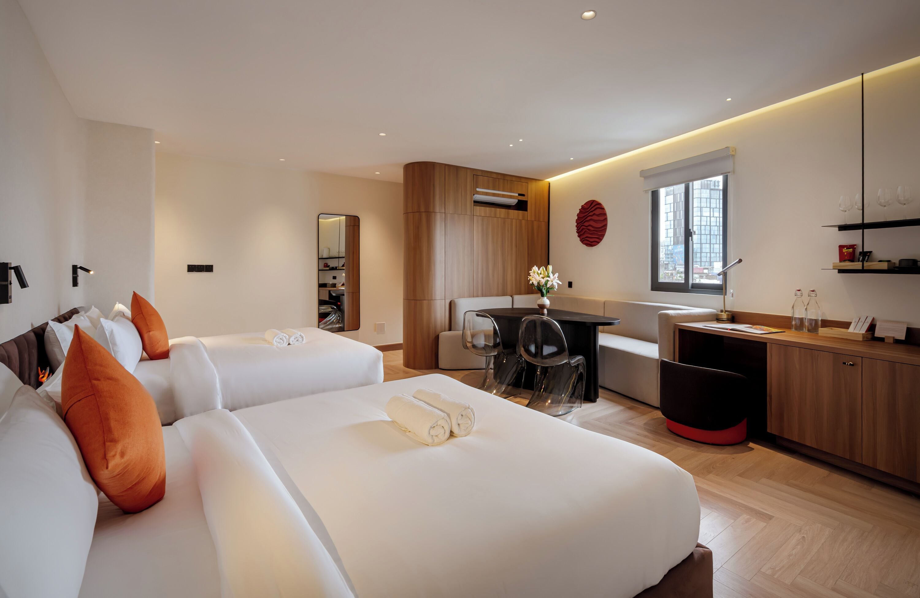 Une chambre d’hôtel avec deux lits, un bureau et une kitchenette.
