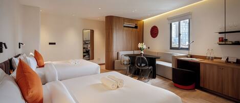 Une chambre d’hôtel avec deux lits, un bureau et une kitchenette.