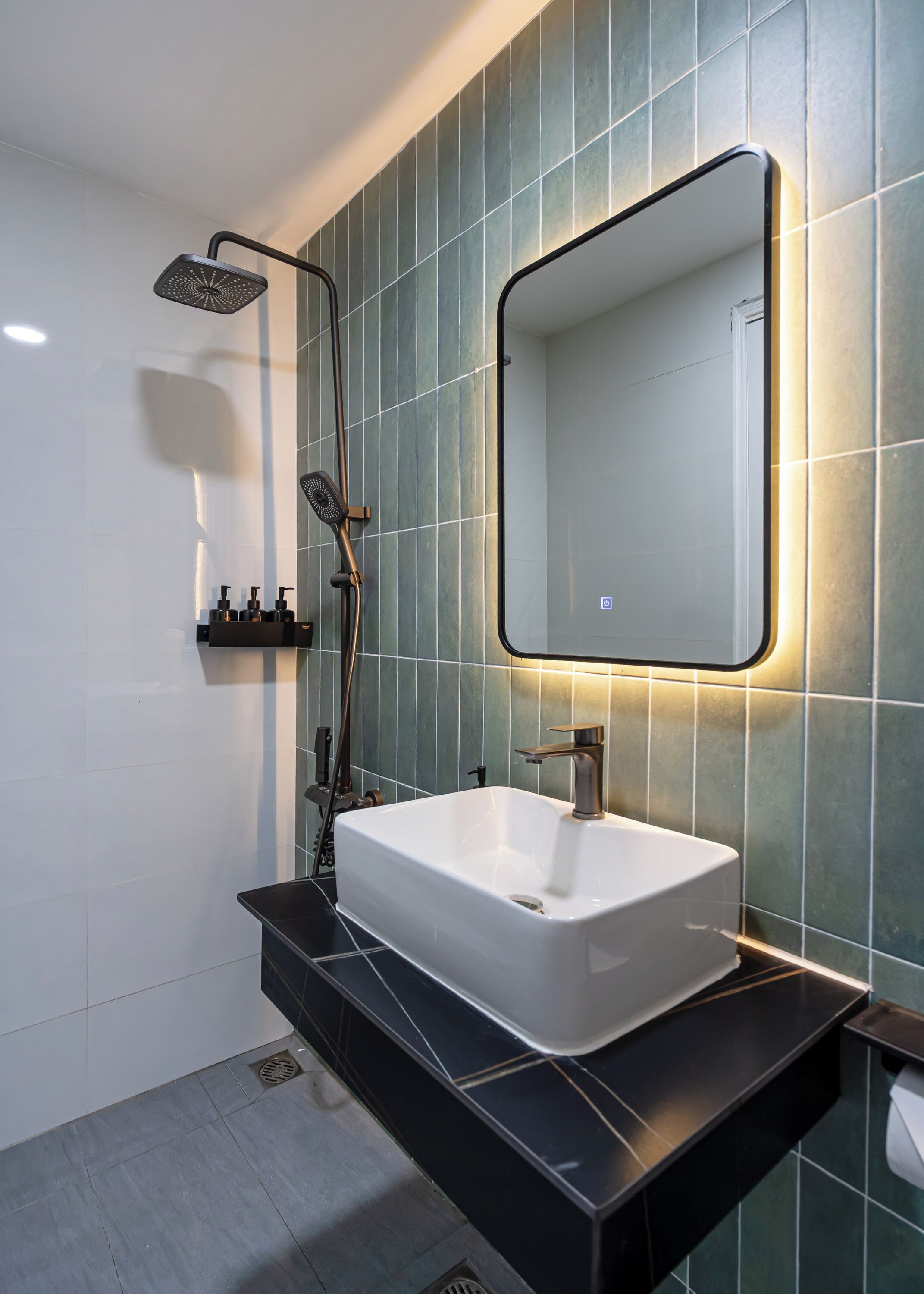 Une salle de bain moderne avec un lavabo blanc, un plan de toilette noir et un grand miroir.