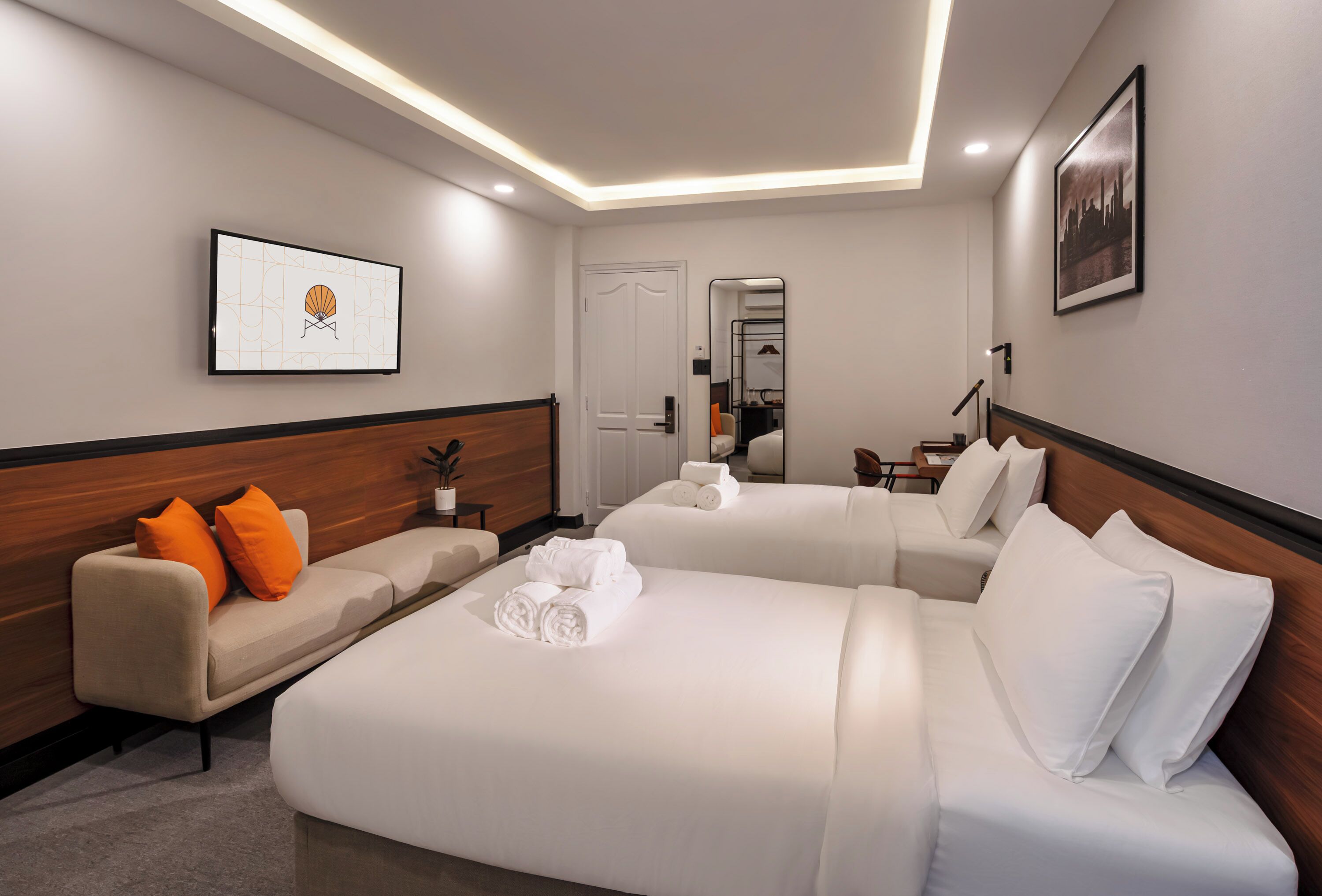 Quarto de hotel com uma cama grande, um sofá e um espelho.