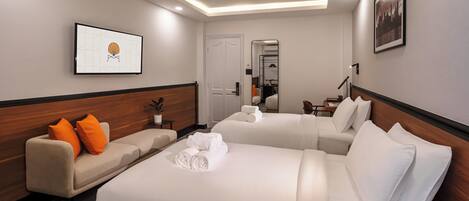 Quarto de hotel com uma cama grande, um sofá e um espelho.