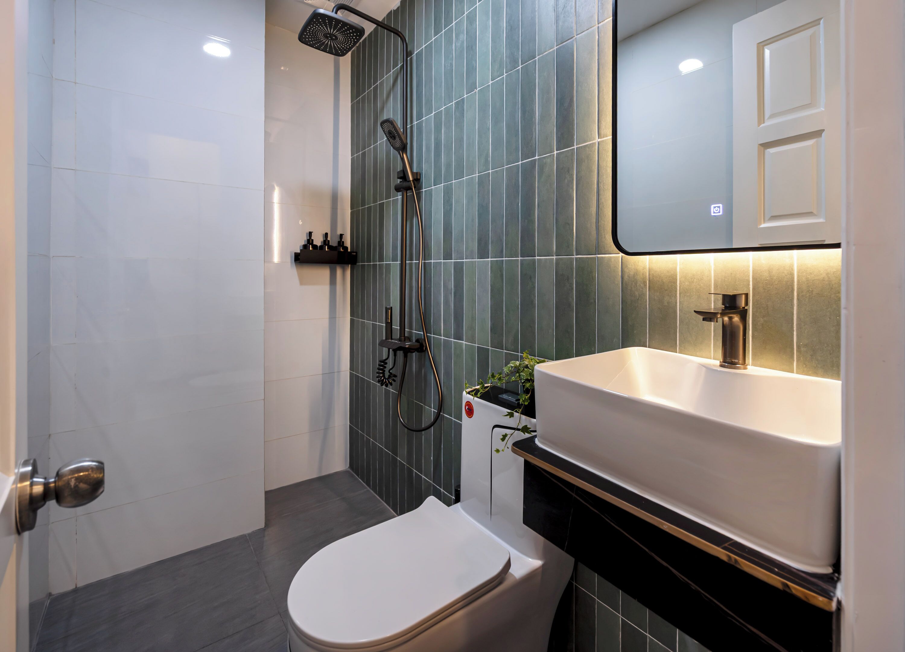 A modern bathroom with a shower, toilet, and sink.