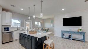 A modern kitchen with a central island, built-in appliances, and pendant lighting. - Private Heated Pool, Golf Cart Included, Short Walk to the Beach (Port Aransas)
