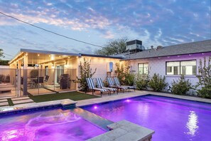 A modern house with a swimming pool, outdoor seating, and a covered patio area. - Moody Modern Desert Retreat – Backyard Bliss Awaits (Scottsdale)