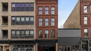 A row of multi-story buildings with various storefronts, including a visible sign for 'Gettin Hitted 4Ever' and 'Choose Love'.