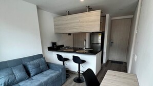 A compact living space with a sofa, a dining table, and a kitchenette. - Welcome to your perfect getaway in the heart of Bogota (Bogotá)